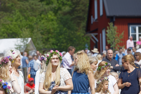 VADDO, SWEDEN - JUNE 23, 2017: Blonde women with flowers in their hair preparing to celebrate the Swedish Midsummer in Sweden, June 23, 2017のeditorial素材