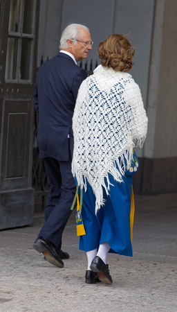 STOCKHOLM, SWEDEN - JUN 06, 2018: Rear view of the swedish queen and king Silvia and Carl Gustaf Bernadotte XVI outside the castle to celebrate the swedish national day June 06 in Stockholmの写真素材