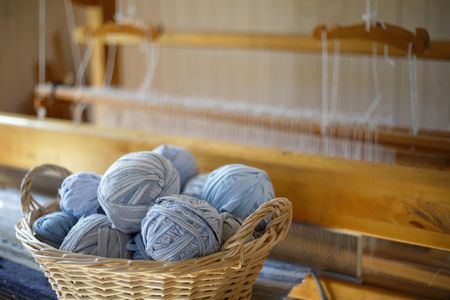 Closeup of basket full of a blue, white and brown ball of matte crumble. A loom in the backgroundの写真素材