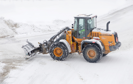 STOCKHOLM, SWEDEN - FEB 03, 2019: Snow clearance using tractor equipped with ploughs on the streets...
