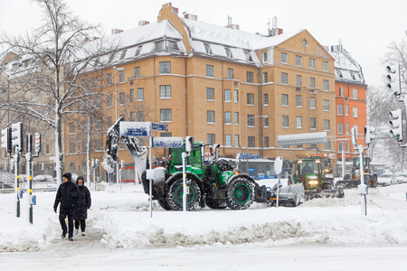 STOCKHOLM, SWEDEN - FEB 03, 2019: Snow clearance using tractors equipped with ploughs on the streets of Stockholm, February 03, 2019 in Stockholm, Swedenのeditorial素材