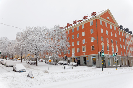STOCKHOLM, SWEDEN - FEB 03, 2019: Winter and snow on the streets and pavement, many parked cars covered with snow, buildings and trees in the background. February 03, 2019 in Stockholm, Swedenのeditorial素材