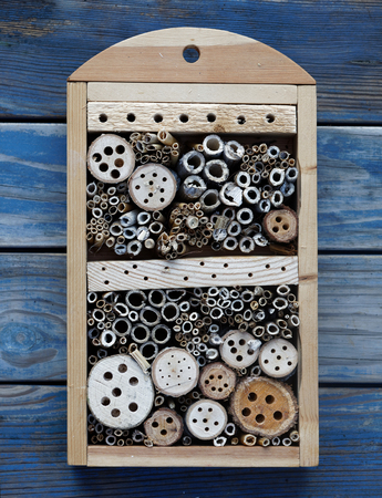 Insect hotel made of reed and drilled holes in wood of different diameter to suit all kind of insectsの写真素材