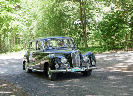 STOCKHOLM, SWEDEN - MAY 20, 2018: Black color BMW V8 3.2 classic car from 1964 driving in the public race Gardesloppet in the forests at Djurgarden, Stockholm, Sweden. May 20, 2018のeditorial素材