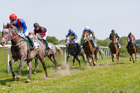 STOCKHOLM, SWEDEN - JUNE 06, 2019: Tough fight between many jockeys riding arabian race horses, trees in the background at ATG Nationaldags Galoppen at Gardet. June 6, 2019 in Stockholm, Swedenのeditorial素材