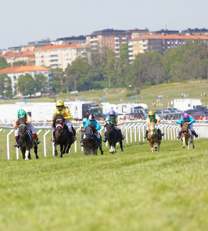 STOCKHOLM, SWEDEN - JUNE 06, 2019: Many young jockey girls riding ponys in a gallop race at Nationaldags Galoppen at Gardet. June 6, 2019 in Stockholm, Swedenのeditorial素材