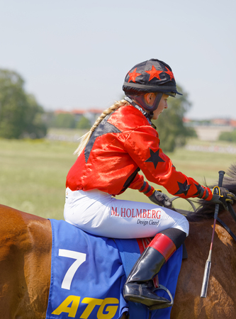 STOCKHOLM, SWEDEN - JUNE 06, 2019: Closeup of jockey Malin Holmberg riding a gallop horse at ATG Nationaldags Galoppen at Gardet. June 6, 2019 in Stockholm, Swedenのeditorial素材