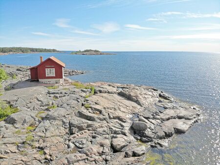 Red traditional cottage in the swedish archipelago a sunny summer dayの写真素材