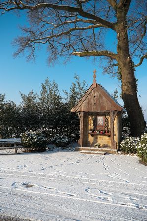 little chapel under tree in snowy landscapeの写真素材