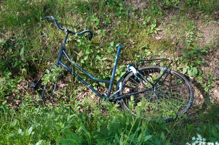 damaged and stripped bike thrown in a ditch as a result of vandalismの写真素材