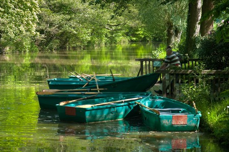 two men are pulling out a row boat out of the water for cleaning. It is on the Alstatter Aa on the border between Germany end Netherlandsの写真素材