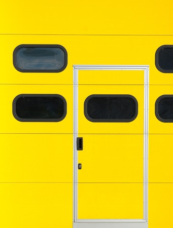 smaller door in a yellow roller door as part of a warehouseの写真素材