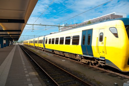 yellow train waiting on the train platform の写真素材