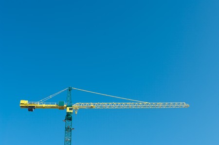 yellow crane against blue saturated skyの写真素材