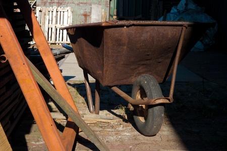 rusty wheelbarrow on a desolate sawmillの写真素材