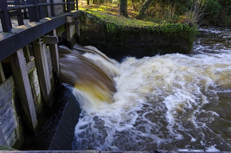 flowing water coming outside an old sluiceの写真素材