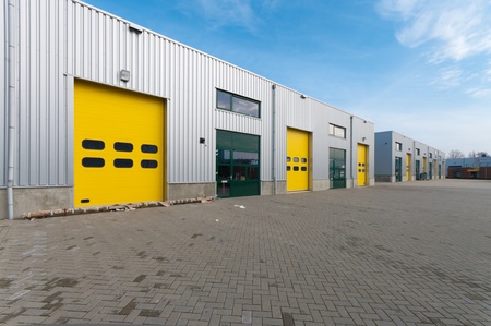 industrial warehouse with green and yellow roller doorsの写真素材
