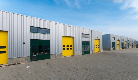 industrial warehouse with green and yellow roller doorsの写真素材