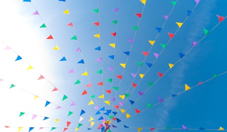 bunting flags blowing in the wind against a saturated blue skyの写真素材