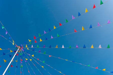 bunting flags blowing in the wind against a saturated blue skyの写真素材