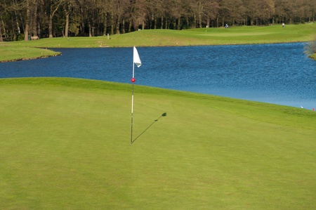 golf course with white flag and water barrierの写真素材