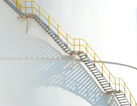 stairs leading to the top of a large white tank for petrol and oil in the Rotterdam harborの写真素材