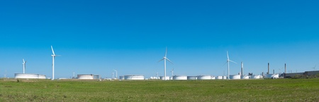 windmills between large white tanks for petrol and oil in the Rotterdam harborの写真素材