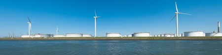 windmills between large white tanks for petrol and oil in the Rotterdam harborの写真素材
