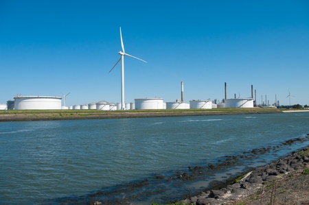 windmills between large white tanks for petrol and oil in the Rotterdam harborの写真素材