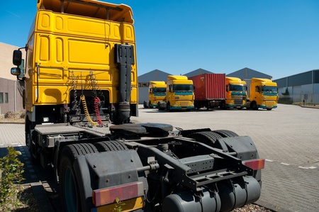 yellow trucks parked on an industrial areaの写真素材