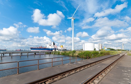 chemical tankers moored in amsterdam harbor next to a large windturbine and railroadのeditorial素材