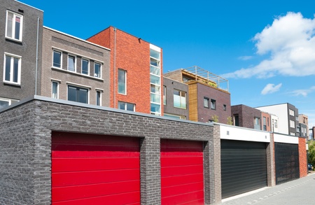 red garage doors belonging to a row newly built modern housesの写真素材