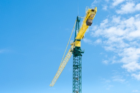 yellow with green crane against a partly clouded blue skyの写真素材