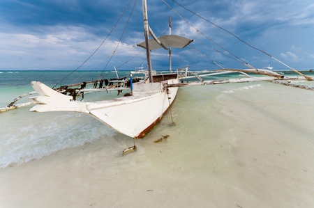 traditional philippine bangka at low tideの写真素材