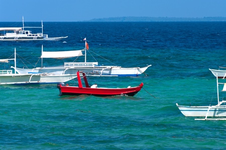 red motorboat together with many traditional philippine bangkasのeditorial素材