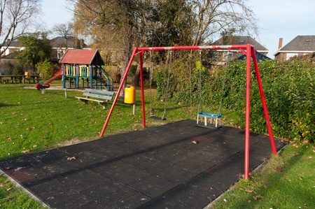 children's playground with a double red swingの写真素材