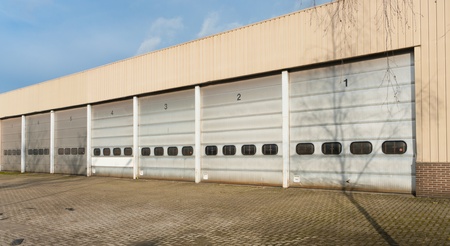 industrial unit with old and damages roller shutter doorsの写真素材