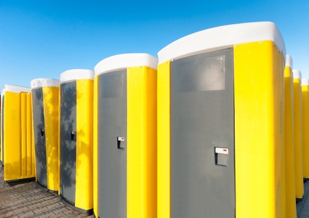 yellow portable toilets under a nice cloudy skyの写真素材