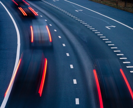 blurred lights of cars on a highway at eveningの写真素材