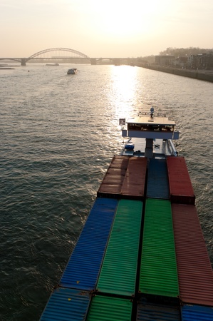 ship full with cargo containers on the Waal river at Nijmegen, netherlands