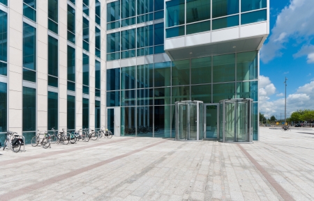 entrance of a modern office building with revolving doorsの写真素材