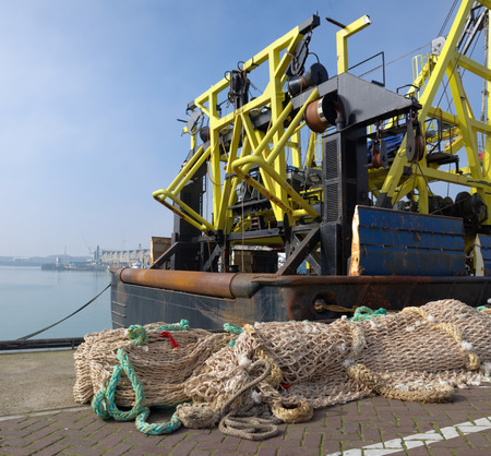 fishing nets in front of a fishing trawler in the scheveningen harbor in the netherlands