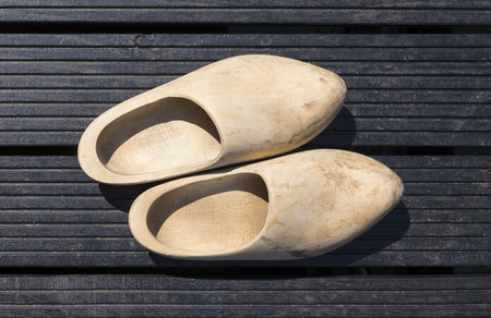 traditional handmade wooden shoes on dark wooden boardsの写真素材