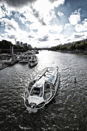 tourist boat on the seine river seen from the Bir-Hakeim bridge at the eiffel tower in parisのeditorial素材