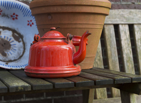 vintage red kettle as backyard decoration
