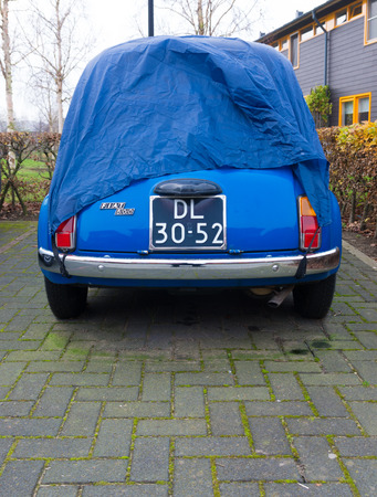 DEVENTER, NETHERLANDS - NOVEMBER 29, 2014: Blue fiat 500 under a protection hose. The Fiat 500 was...