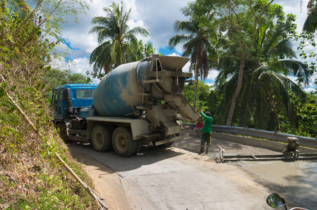 DONSOL, PHILIPPINES - JUNE 2, 2015: Unknown road workers with a cement truck building a new forest road in the philippinesのeditorial素材