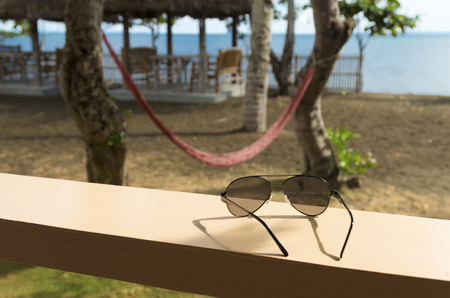 sunglasses in front of a tropical beach restaurantの写真素材