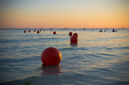 orange buoys at sunset in a tropical seaの写真素材