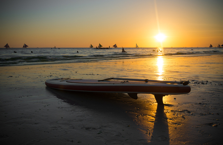 surfboard on a tropical beach during a beautiful sunsetの写真素材